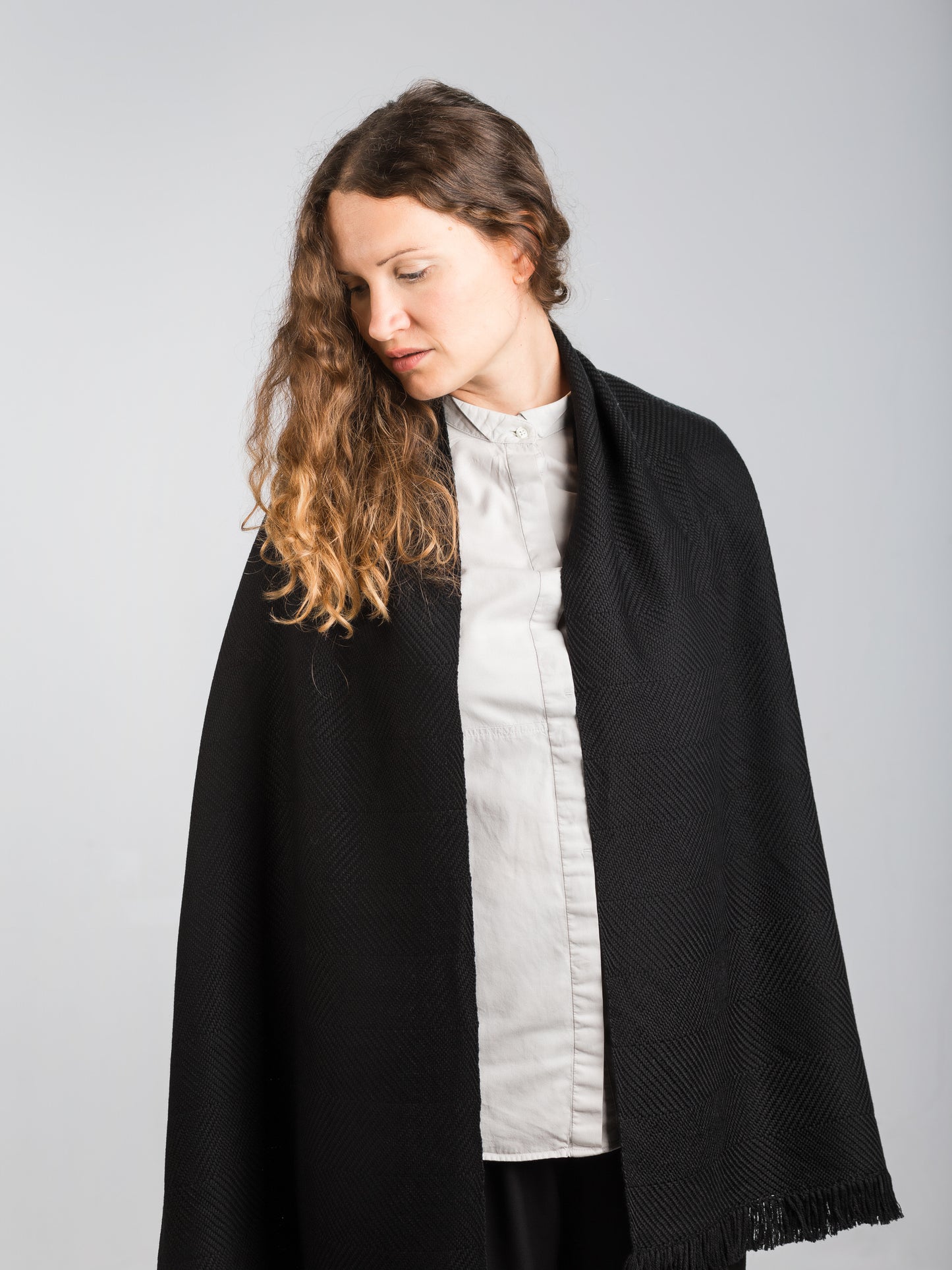 Scialle tessuto a mano in pura lana merino, colore nero, su modella