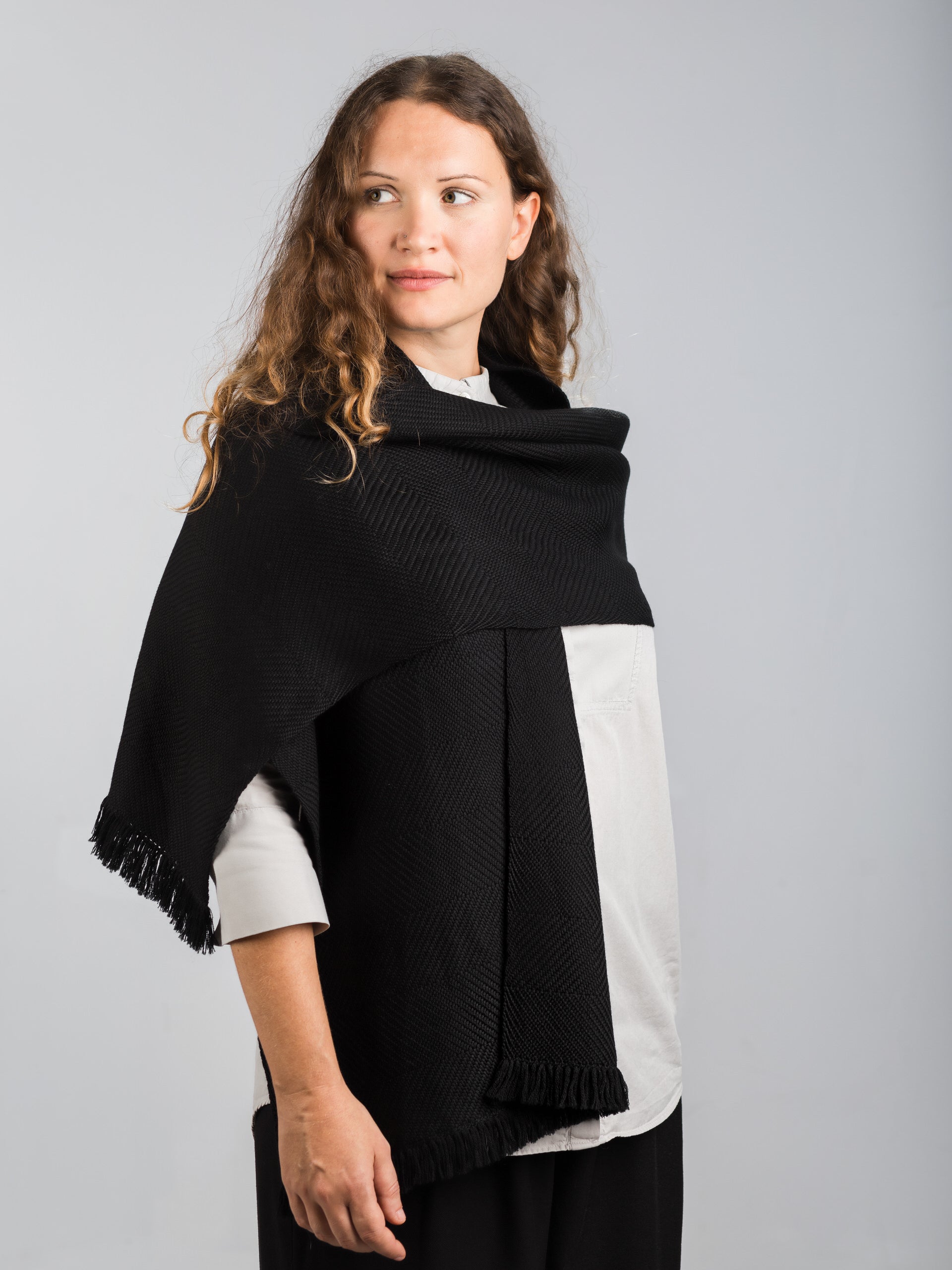 Scialle tessuto a mano in pura lana merino, colore nero, su modella