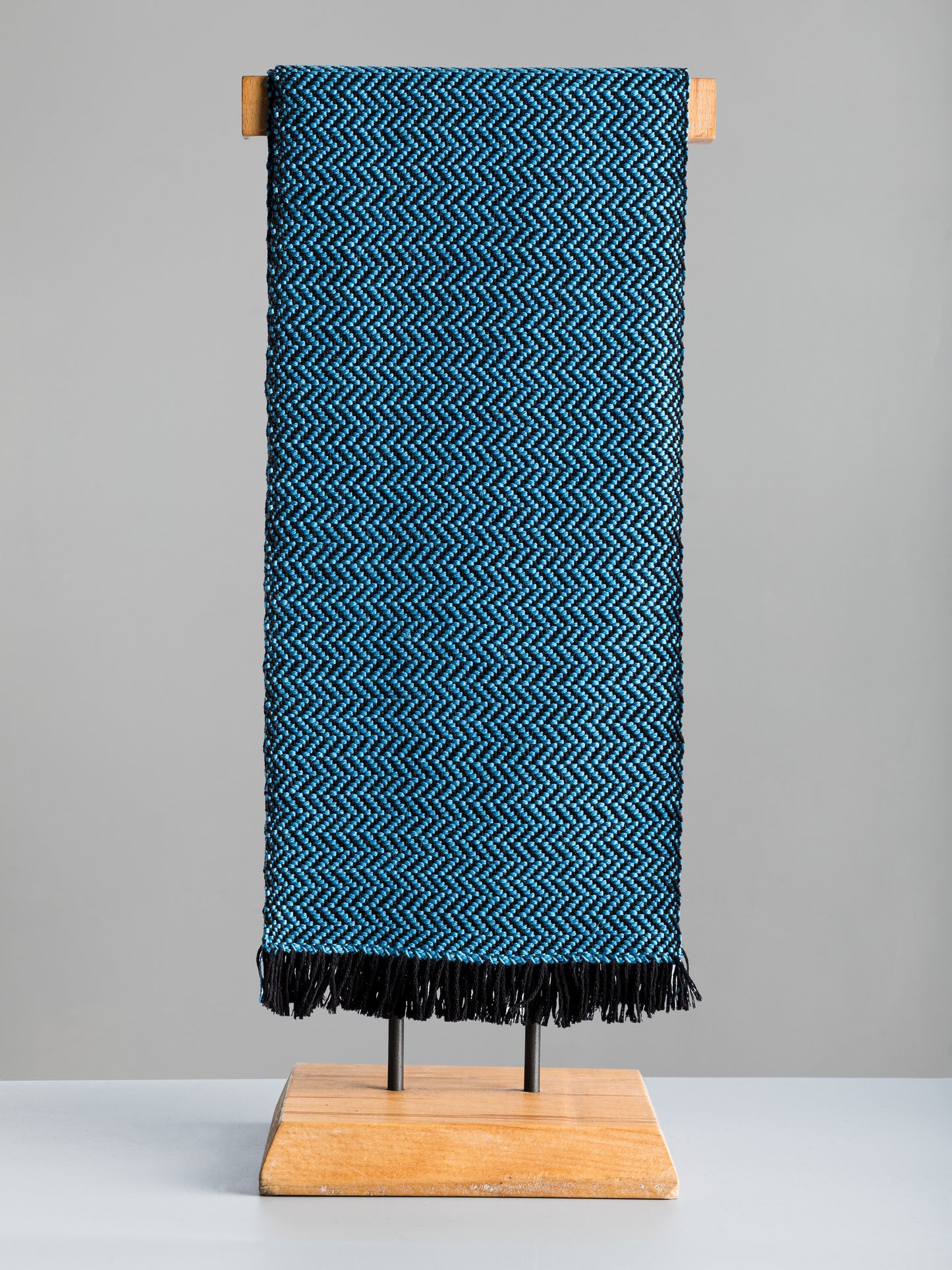 Sciarpa tessuta a mano in pura lana merino, colore azzurro, su manichino