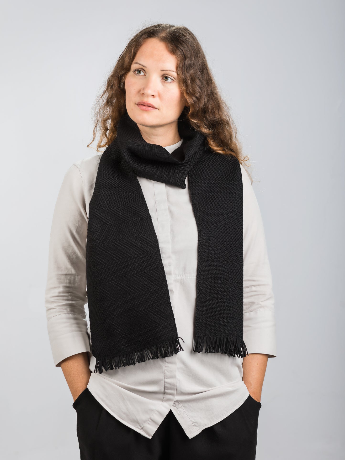 Sciarpa tessuta a mano in pura lana merino, colore nero, su modella