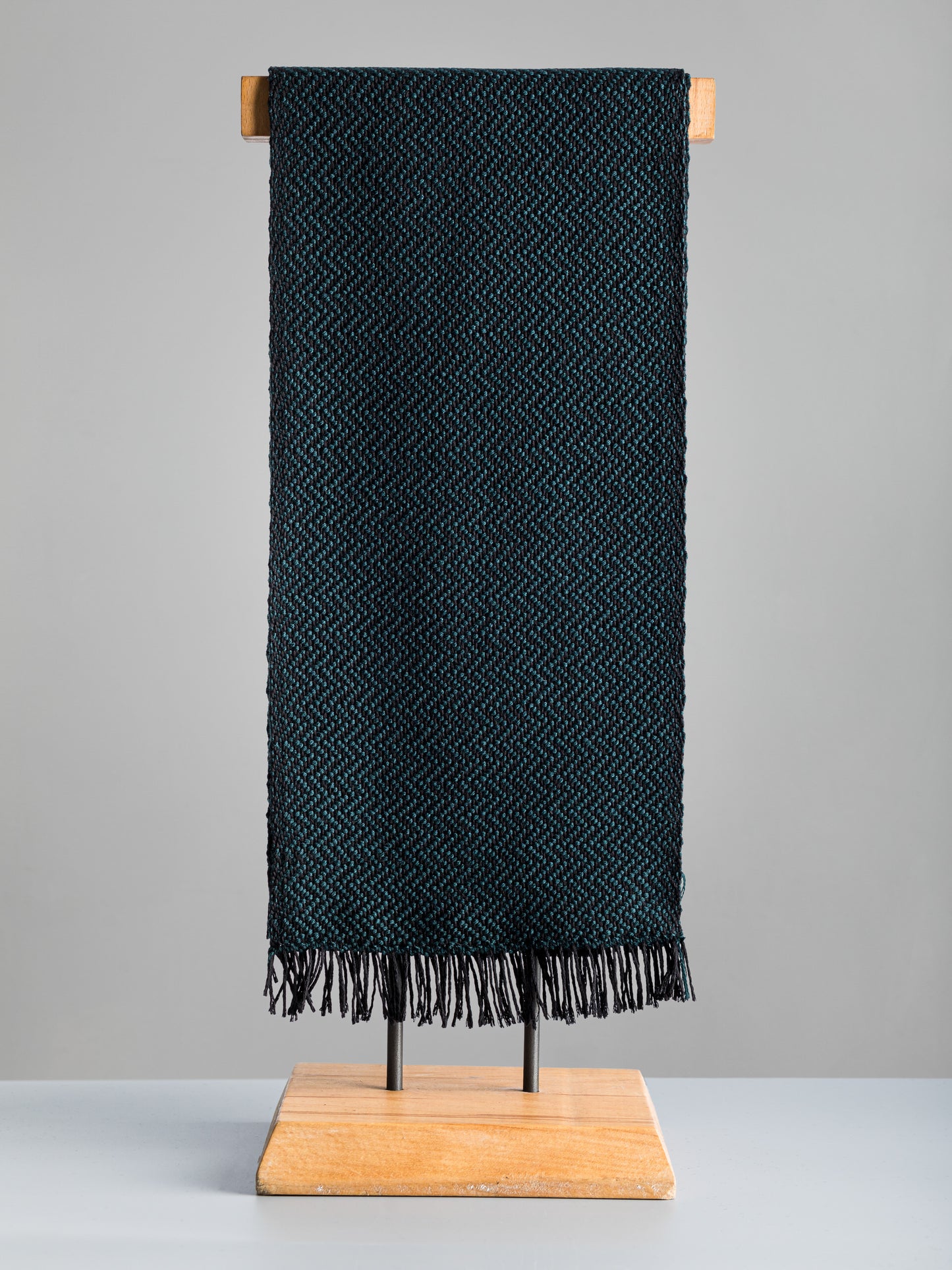 Sciarpa tessuta a mano in pura lana merino, colore verde petrolio, su manichino