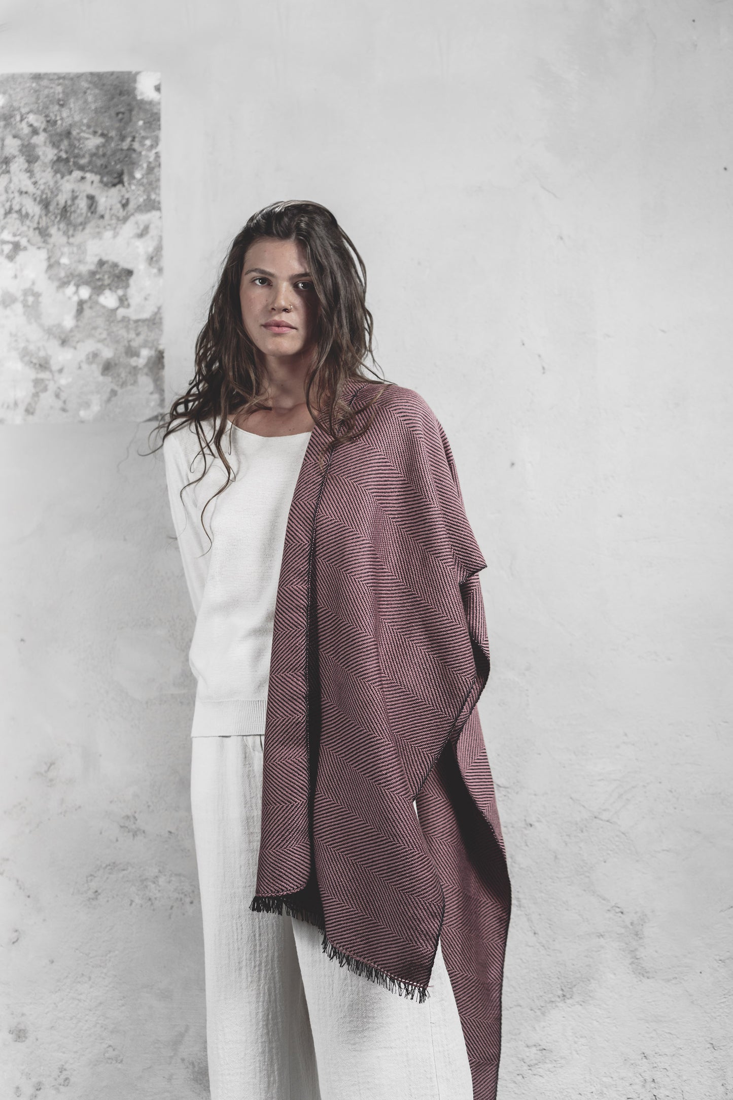 Modella con scialle rosa antico tessuto a mano, sfondo bianco